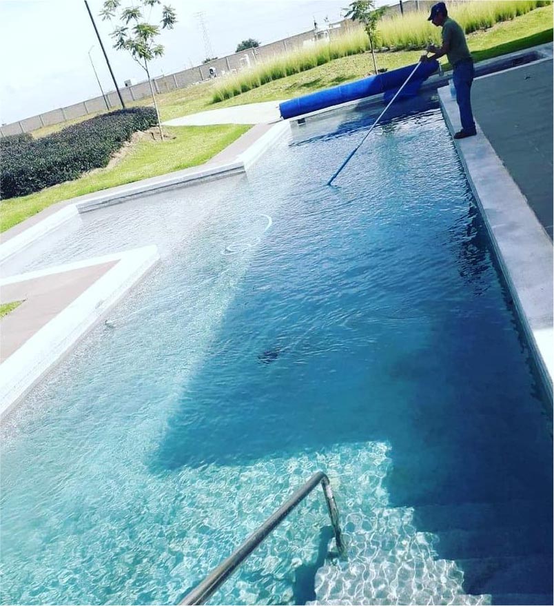 [Persona limpiando una alberca]